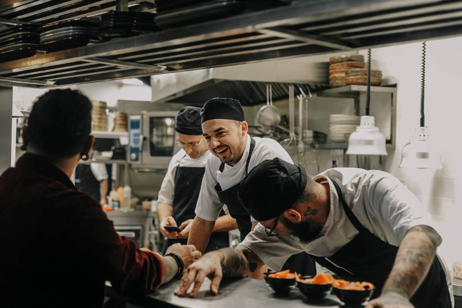 chefs in kitchen laughing, positive atmosphere at work