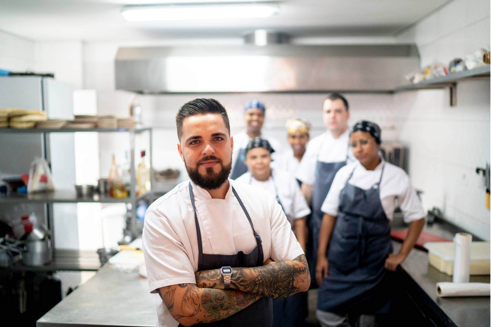 Reducing employee turnover in restaurants, manager with team behind him.