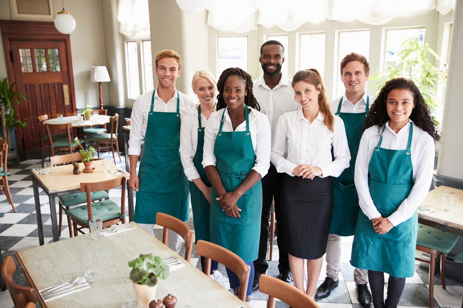 Restaurant team standing together in uniform, smiling and ready for a shift, symbolizing teamwork and accountability without micromanagement.